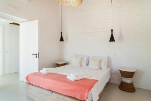 1 dormitorio blanco con 1 cama con manta roja en Monte Muro Country House, en Monsaraz