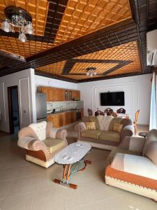 a large living room with couches and a kitchen at Armando's wooden roof in Berat
