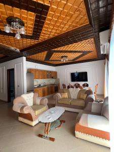 a living room with couches and a table and a kitchen at Armando's wooden roof in Berat