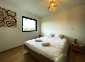 a bedroom with a bed with two towels on it at maison Porzh Loaz. in Plouézec