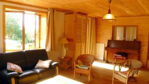 a living room with a couch and a piano at Les hauts de Saint Christaud in Pallanne