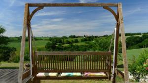 a swing with a view of the green hills at Les hauts de Saint Christaud in Pallanne