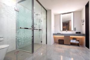 un bagno con doccia in vetro e lavandino di Hampton by Hilton Guigang a Guigang