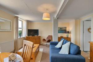 a living room with a blue couch and a table at Finest Retreats - No 11 Porthminster in St Ives
