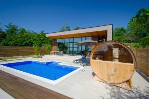 a swimming pool and an umbrella in front of a house at Morris Resort Tohginbow in Sakai