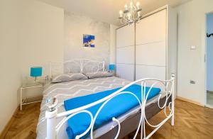 a bedroom with a white bed with blue sheets at Villa Vinodol *with great sea view and pool in Novi Vinodolski +43 photos