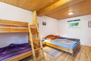 two bunk beds in a room with wooden ceilings at Ferienwohnungen Lindenhof in Eimelrod