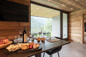 a dining room with a table with a bottle of wine at Ledarix Charm Chalet in Ledro