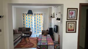 a living room with a couch and a table at Private chalet in Amwaj north coast 2 bed room and 2 bath امواج الساحل الشمالي شاليه غرفتين واتنين حمام مفروش ومكيف بالكامل in El Alamein