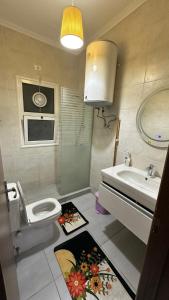 a bathroom with a toilet and a sink and a mirror at Private chalet in Amwaj north coast 2 bed room and 2 bath امواج الساحل الشمالي شاليه غرفتين واتنين حمام مفروش ومكيف بالكامل in El Alamein