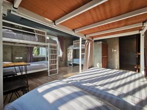 una camera da letto con due letti a castello e un tavolo di Hi Samui Hostel a Choeng Mon Beach