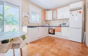 a kitchen with white cabinets and a tile floor at 4 Bedroom Amazing Home In Cunit in Cunit