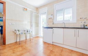 a kitchen with white cabinets and a table at 4 Bedroom Amazing Home In Cunit in Cunit