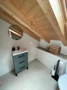 a bathroom with a sink and a mirror at A Chupiña in Balboa +11 photos