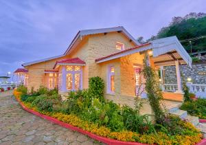 ein Haus mit einem Garten davor in der Unterkunft Taj Mahal Vintage Villa by VOYE HOMES in Kodaikanal
