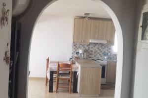 a kitchen with an archway leading into a kitchen with a table at Κτήμα Καστέλι in Paralia Demonias