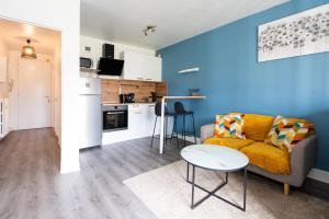 a living room with a couch and a table at Le Studio du commandant in Évreux