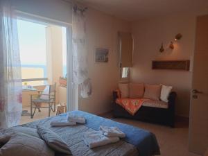 una camera da letto con un letto, un divano e una finestra di Volissos Holiday Homes a Volissos