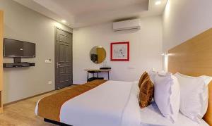 a bedroom with a large white bed and a television at Via Wedding Hut 51 in Gurgaon