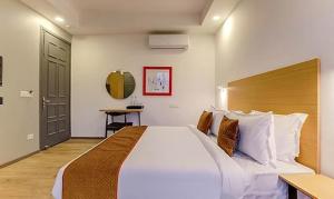 a bedroom with a large white bed and a desk at Via Wedding Hut 51 in Gurgaon