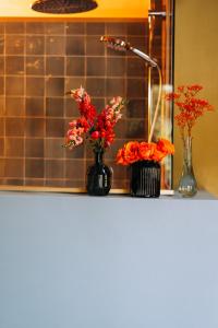 two vases with flowers on a counter in a kitchen at Bräustüberl Schönbrunn - Hotel & Restaurant in Wunsiedel