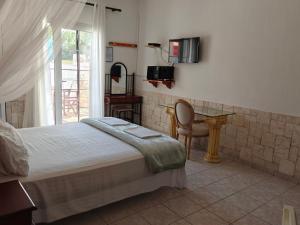 a bedroom with a bed and a table and a window at Villa Askamnia and Suites in Nikiti +116 photos