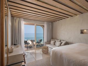 a bedroom with a bed and a view of the ocean at The Theodore Boutique Hotel- adults only 16 plus in Agia Marina Nea Kydonias