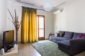 sala de estar con sofá y TV en Your Room in Catania, en Catania