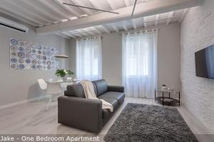 un salon avec un canapé et une télévision dans l'établissement Jake & Francis Apartments by Mamo Florence, à Florence