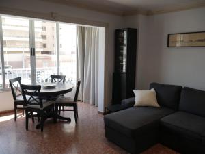 a living room with a couch and a table and chairs at Malvarrosa, 1-6 in Cullera