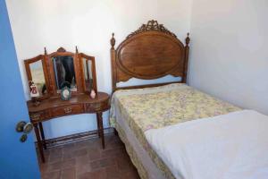 a bedroom with a bed and a dresser with a mirror at Villa Mon Bonheur in Altura