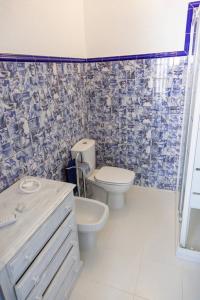 a bathroom with a toilet and a sink at Villa Mon Bonheur in Altura