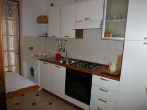 a kitchen with a stove and a sink and a washing machine at Suite Angelica in Iglesias +4 photos