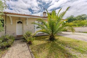 a palm tree in front of a house at La Bohème du Lac - Maison climatisée avec piscine in La Teste-de-Buch