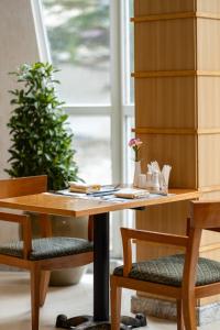 a wooden table with two chairs and a book shelf at Lebanshan Hotel Jiuzhai Valley in Jiuzhaigou