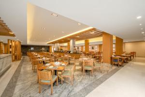a dining room with wooden tables and chairs at Lebanshan Hotel Jiuzhai Valley in Jiuzhaigou
