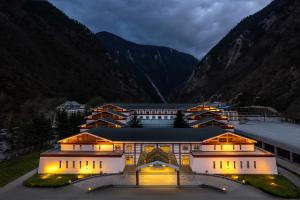 a large building in front of a mountain at Lebanshan Hotel Jiuzhai Valley in Jiuzhaigou