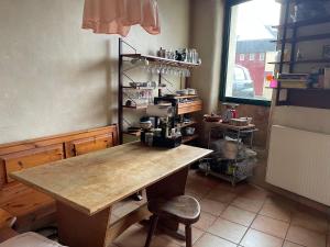 a kitchen with a wooden table and a chair at L'Adventice in Riec-sur-Bélon +3 photos