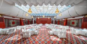 a banquet hall with white tables and white chairs at Lebanshan Hotel Jiuzhai Valley in Jiuzhaigou