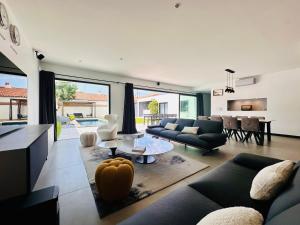 a living room with a couch and a table at L'Escapade - Villa avec piscine in La Rochelle