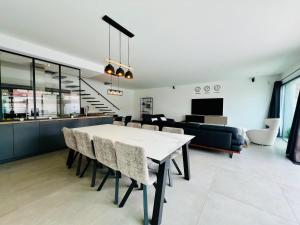 a dining room and living room with a table and chairs at L'Escapade - Villa avec piscine in La Rochelle