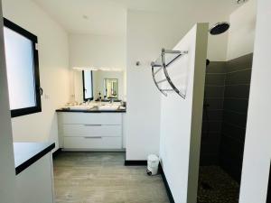 a white bathroom with a sink and a mirror at L'Escapade - Villa avec piscine in La Rochelle +26 photos