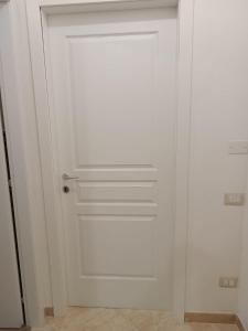 - une porte blanche dans une chambre avec un mur dans l'établissement Adriatica 21 zona centrale, à Montalto di Castro