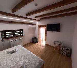 a room with a bed and a television and a table at Casa Bloanca in Bucureasa
