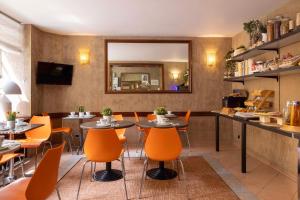 a restaurant with tables and chairs and a mirror at H&ocirc;tel Saint Pierre in Paris