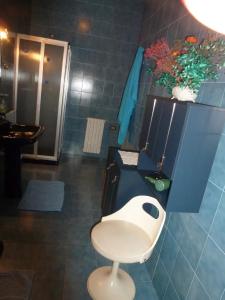 a bathroom with a white chair and a sink at Suite Angelica in Iglesias