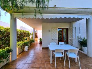 a white table and chairs on a patio at Apulia Beach in Leporano