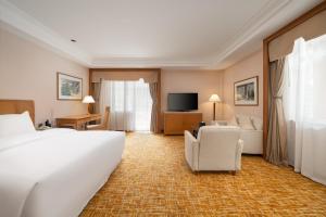 a hotel room with a large bed and a television at Lebanshan Hotel Jiuzhai Valley in Jiuzhaigou