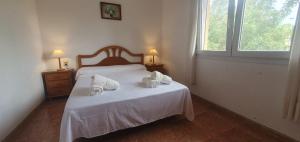 Un dormitorio con una cama con dos toallas encima. en confortable villa at only 100 meter from the beach, supermarkets and the restaurants, en Calpe 13 fotos más