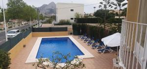 Una piscina con tumbonas al lado de un edificio. en confortable villa at only 100 meter from the beach, supermarkets and the restaurants, en Calpe